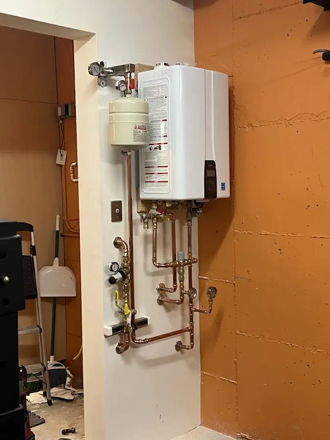 Plumbing technician inspecting water heater connections in Alsace